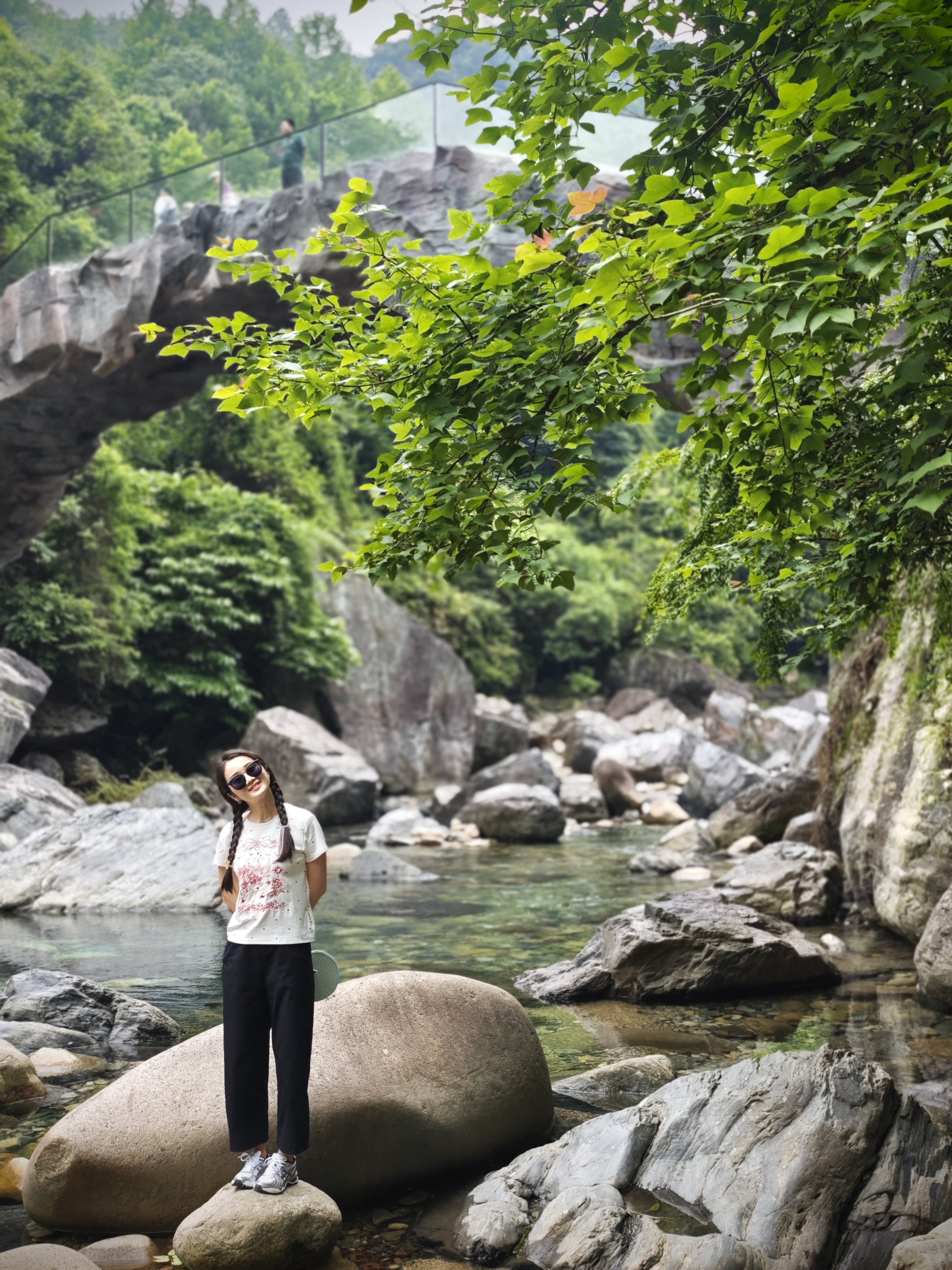 Traveler smiling on rocks near a stream